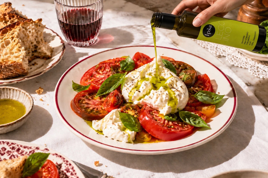 Ipša Leccino Olivenöl wird über Burrata mit Tomaten gegossen